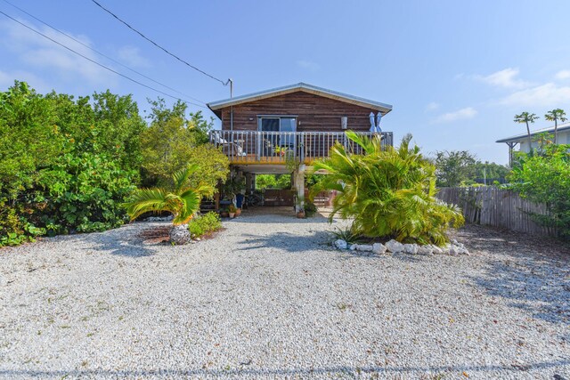 back of house with a wooden deck and a carport