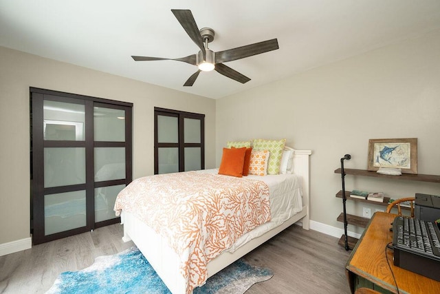 bedroom featuring a ceiling fan, baseboards, and wood finished floors