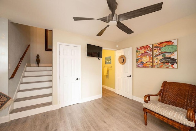 sitting room with stairway, a ceiling fan, baseboards, and wood finished floors