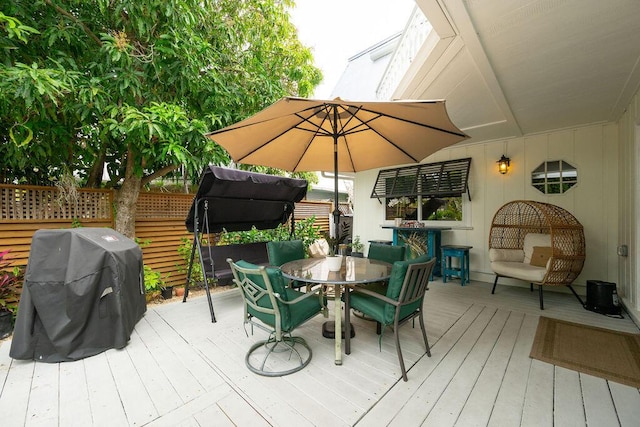 wooden deck featuring grilling area and outdoor dining area