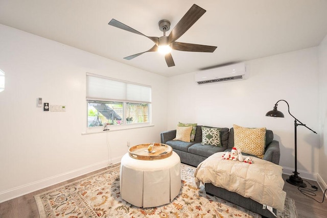 living area with ceiling fan, baseboards, wood finished floors, and a wall mounted air conditioner