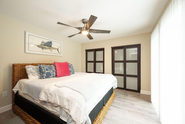 bedroom featuring a ceiling fan, light wood-style flooring, and baseboards