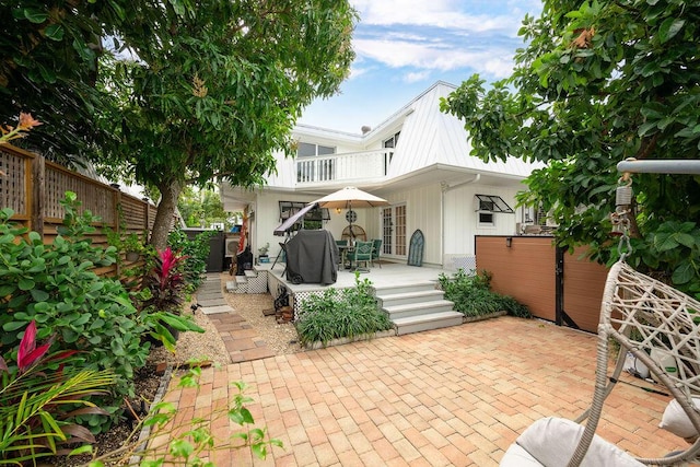 rear view of house featuring a patio, a fenced backyard, and a balcony