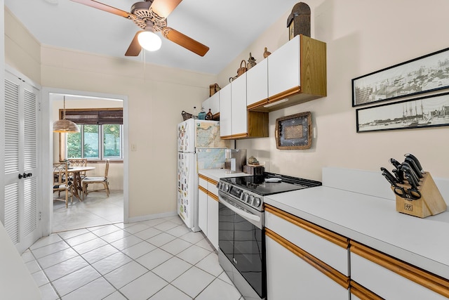 kitchen featuring white cabinets, stainless steel range with electric stovetop, white refrigerator, hanging light fixtures, and light tile patterned floors