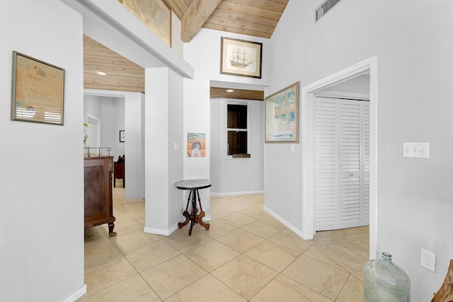 hallway featuring wood ceiling, beam ceiling, light tile patterned flooring, and high vaulted ceiling