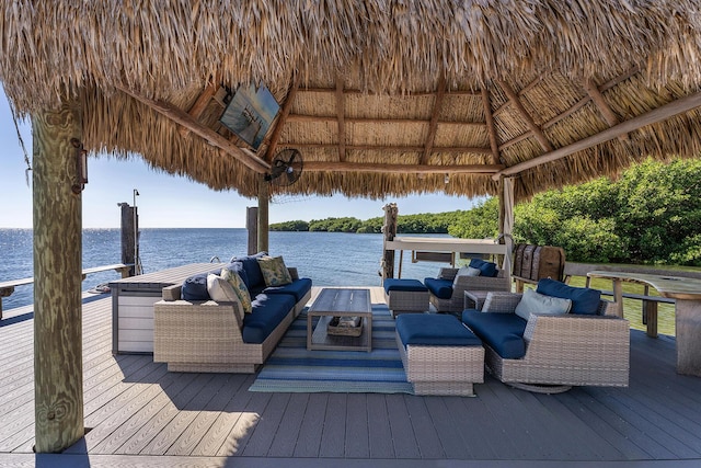 view of dock with a gazebo, a water view, and an outdoor hangout area