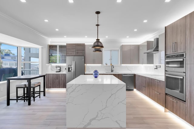 kitchen with stainless steel appliances, modern cabinets, wall chimney range hood, backsplash, and ornamental molding