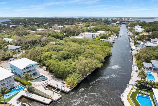 aerial perspective of suburban area with a pool and a nearby body of water