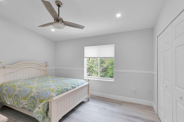 bedroom with a closet, baseboards, wood finished floors, recessed lighting, and a ceiling fan