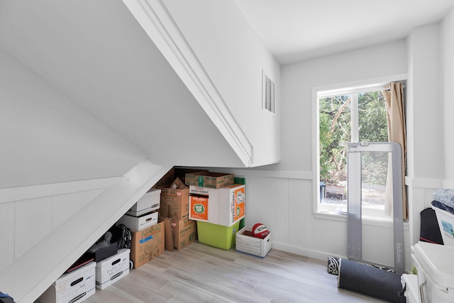 rec room with a wainscoted wall and light wood-style floors