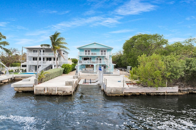 dock with stairs, a balcony, a patio, a water view, and fence