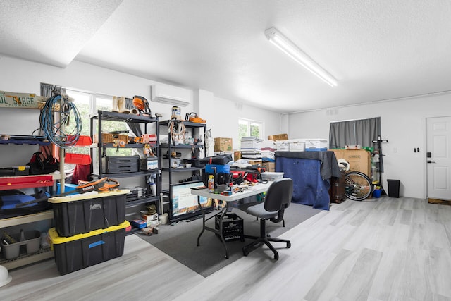 office space featuring a wall mounted AC, wood finished floors, and a textured ceiling