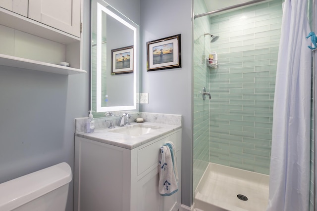 bathroom featuring vanity, a shower stall, and toilet