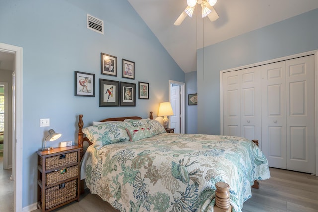 bedroom featuring visible vents, wood finished floors, a closet, lofted ceiling, and ceiling fan