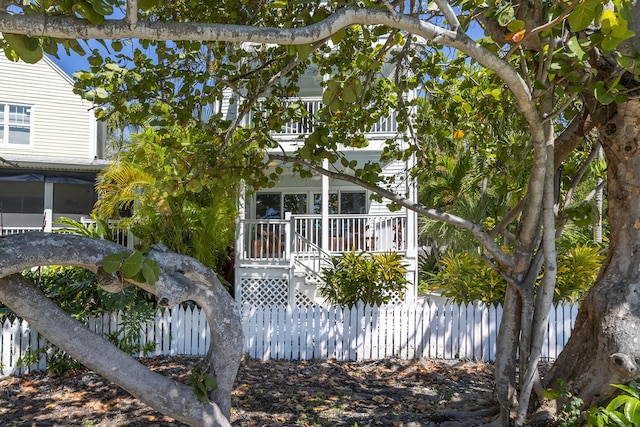 view of front of house featuring a fenced front yard and a balcony