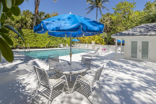 community pool with a patio area, french doors, and fence