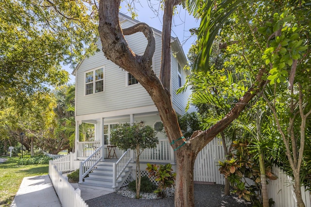 view of front of home with covered porch and fence