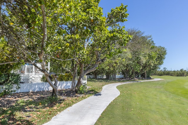 view of property's community with a yard and fence