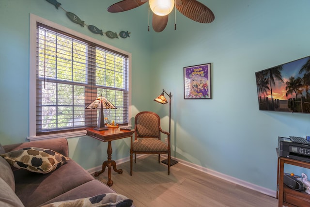 sitting room with baseboards, ceiling fan, and wood finished floors