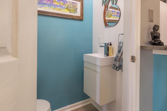 bathroom featuring vanity, toilet, and baseboards