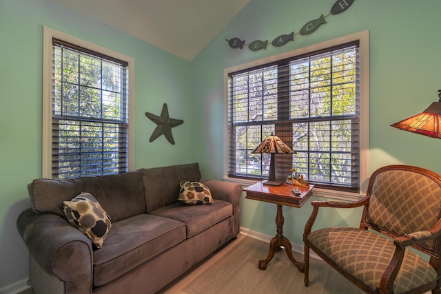 living room featuring baseboards, lofted ceiling, and wood finished floors