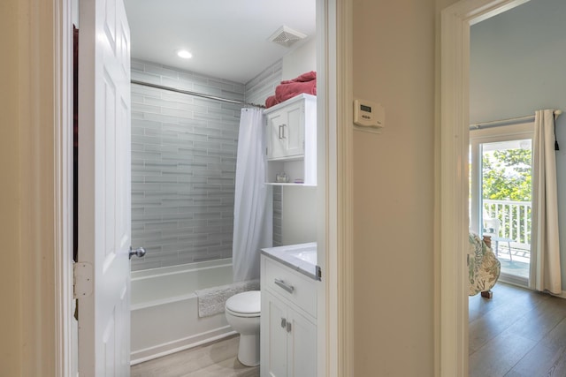 full bath with visible vents, toilet, shower / bath combo, wood finished floors, and vanity