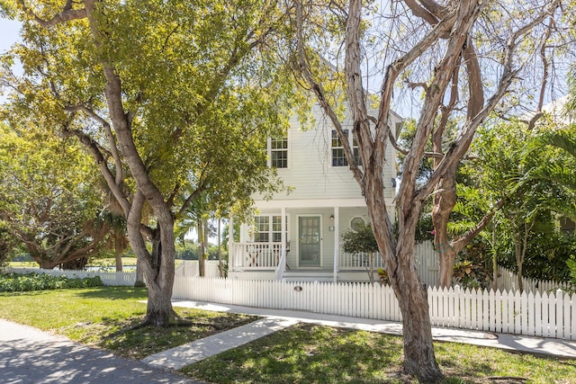 view of front of home featuring a front lawn, covered porch, and a fenced front yard