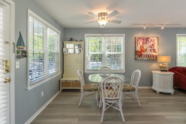 dining space with track lighting, baseboards, ceiling fan, and wood finished floors