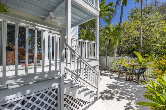 view of patio with stairway, a ceiling fan, and fence