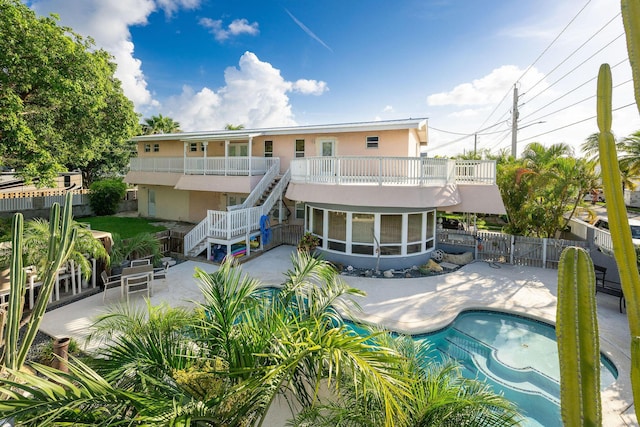 view of swimming pool with a patio and a sunroom