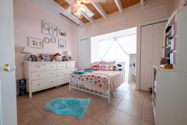 bedroom with tile patterned flooring, ceiling fan, and beamed ceiling