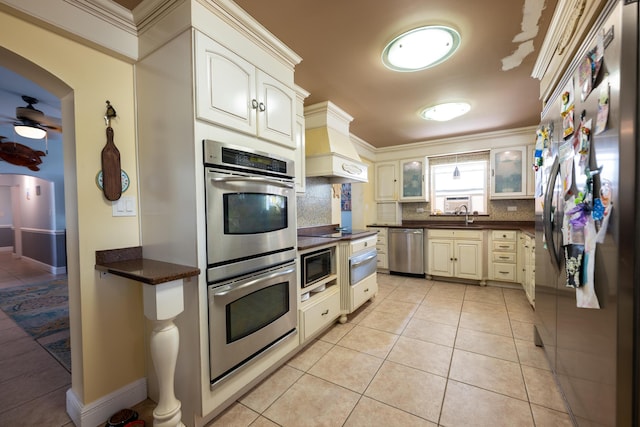 kitchen with tasteful backsplash, custom exhaust hood, light tile patterned floors, ceiling fan, and black appliances