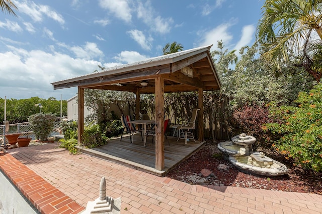 view of patio / terrace with a gazebo, fence, a wooden deck, and outdoor dining space