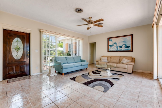 tiled living area with baseboards, a ceiling fan, and visible vents
