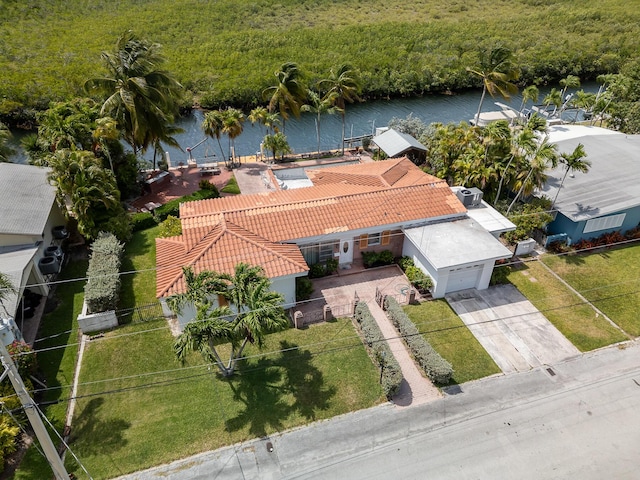 birds eye view of property with a water view and a view of trees