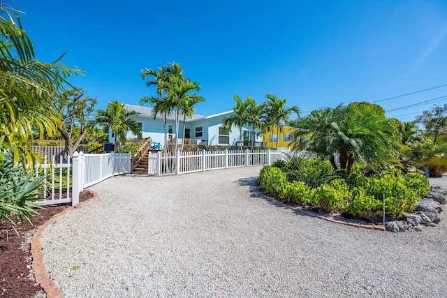 view of front of home featuring gravel driveway and fence