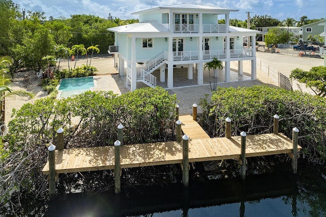 back of property with french doors, a balcony, and a patio