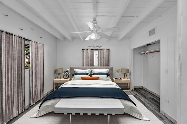 bedroom featuring beam ceiling, a closet, ceiling fan, and hardwood / wood-style flooring