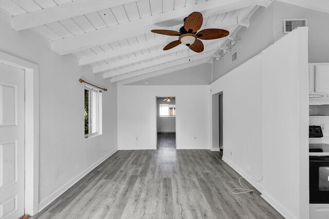 unfurnished living room with lofted ceiling with beams, plenty of natural light, wood ceiling, and light wood-type flooring