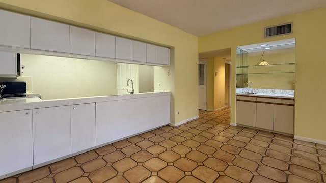 1800 Atlantic Blvd Unit C130, Key West, FL 33040 - kitchen featuring white cabinets, baseboards, light countertops, and a sink