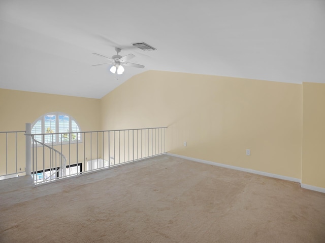 empty room featuring lofted ceiling, carpet, and ceiling fan