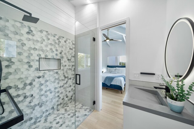 bathroom featuring ceiling fan, wood-type flooring, a shower with shower door, and vanity