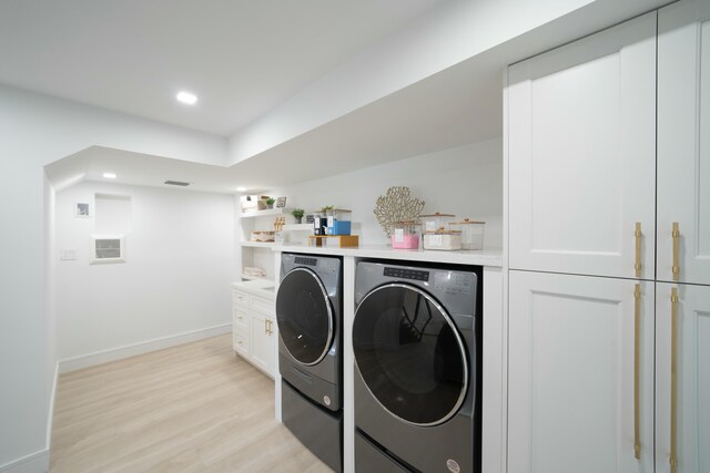 laundry area with cabinets, separate washer and dryer, bar area, and light wood-type flooring