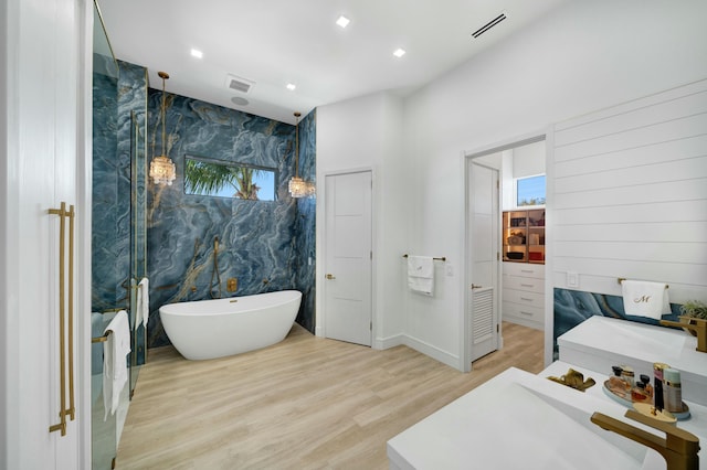 bathroom featuring a bath, wood-type flooring, and sink