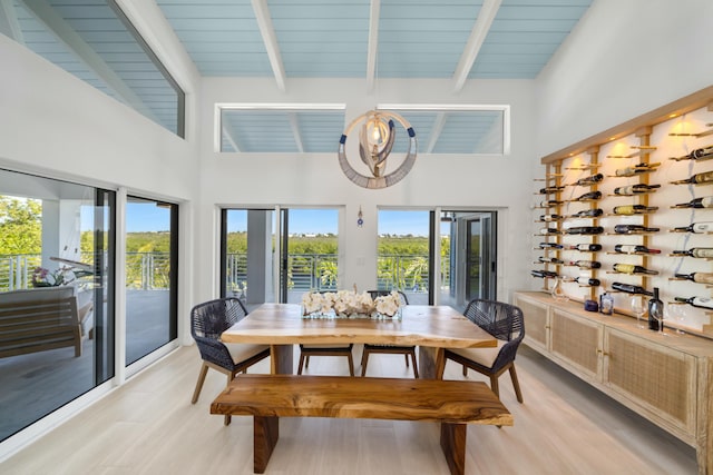 dining space with beamed ceiling, high vaulted ceiling, and light wood-type flooring