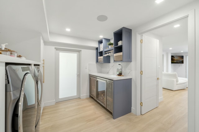 kitchen featuring gray cabinetry, backsplash, washer and clothes dryer, and light hardwood / wood-style floors