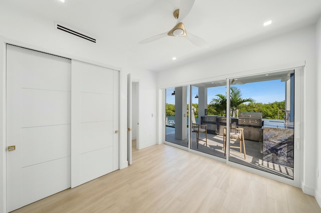 bedroom featuring access to exterior, a closet, ceiling fan, and light wood-type flooring