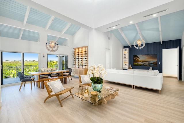 living room with beamed ceiling, high vaulted ceiling, and light wood-type flooring