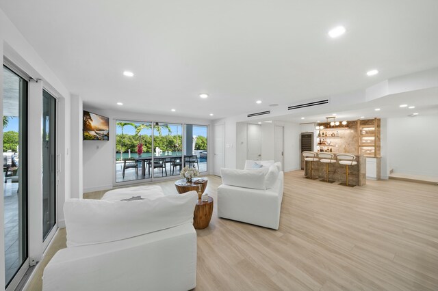 living room with bar and light hardwood / wood-style flooring