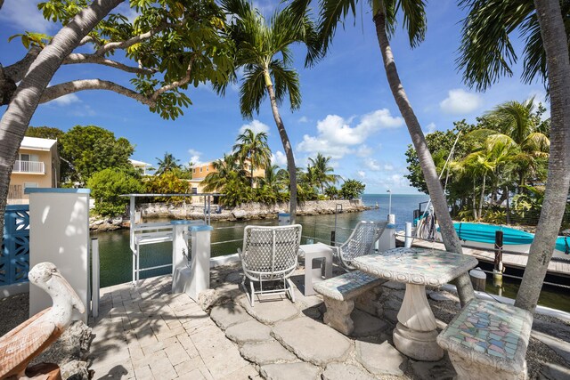 view of patio with a water view and a boat dock